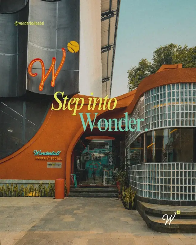 The curved terracotta facade with glass blocks and the neon W