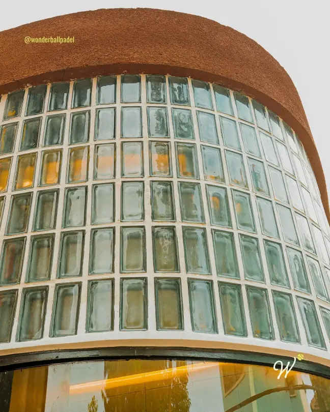 Curved glass-block wall under a terracotta roof
