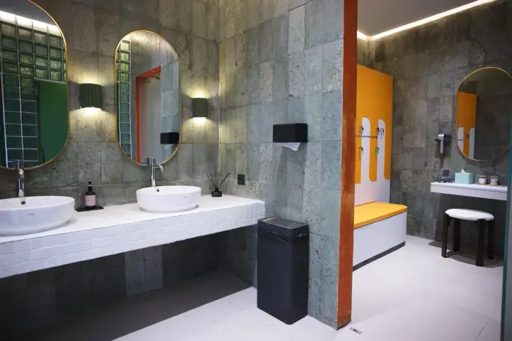 Stone washroom with round mirrors